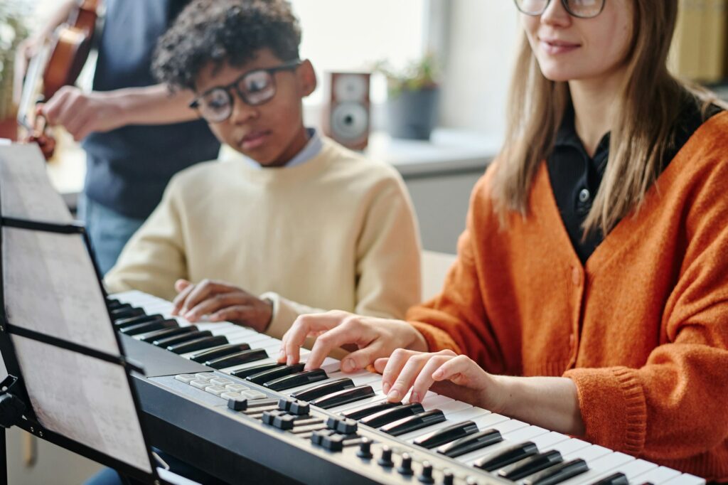 Young Teacher Playing Electronic Piano At Music Class